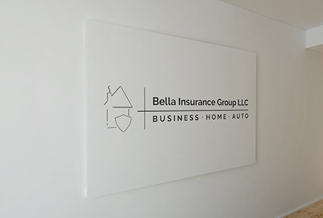 Bella Insurance Group logo printed on a white wall